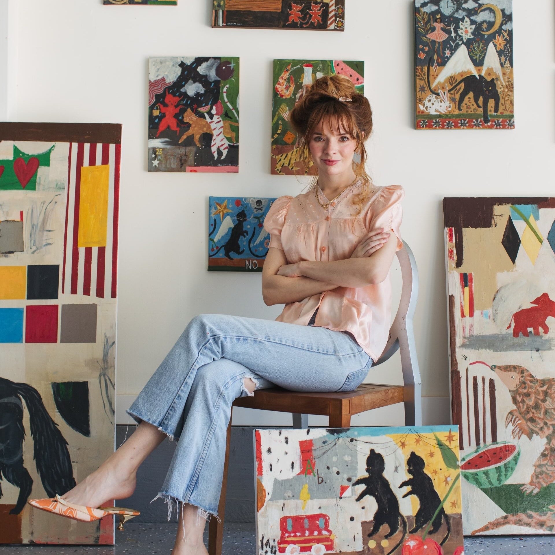 Jane Dashley sitting in studio in front of several paintings